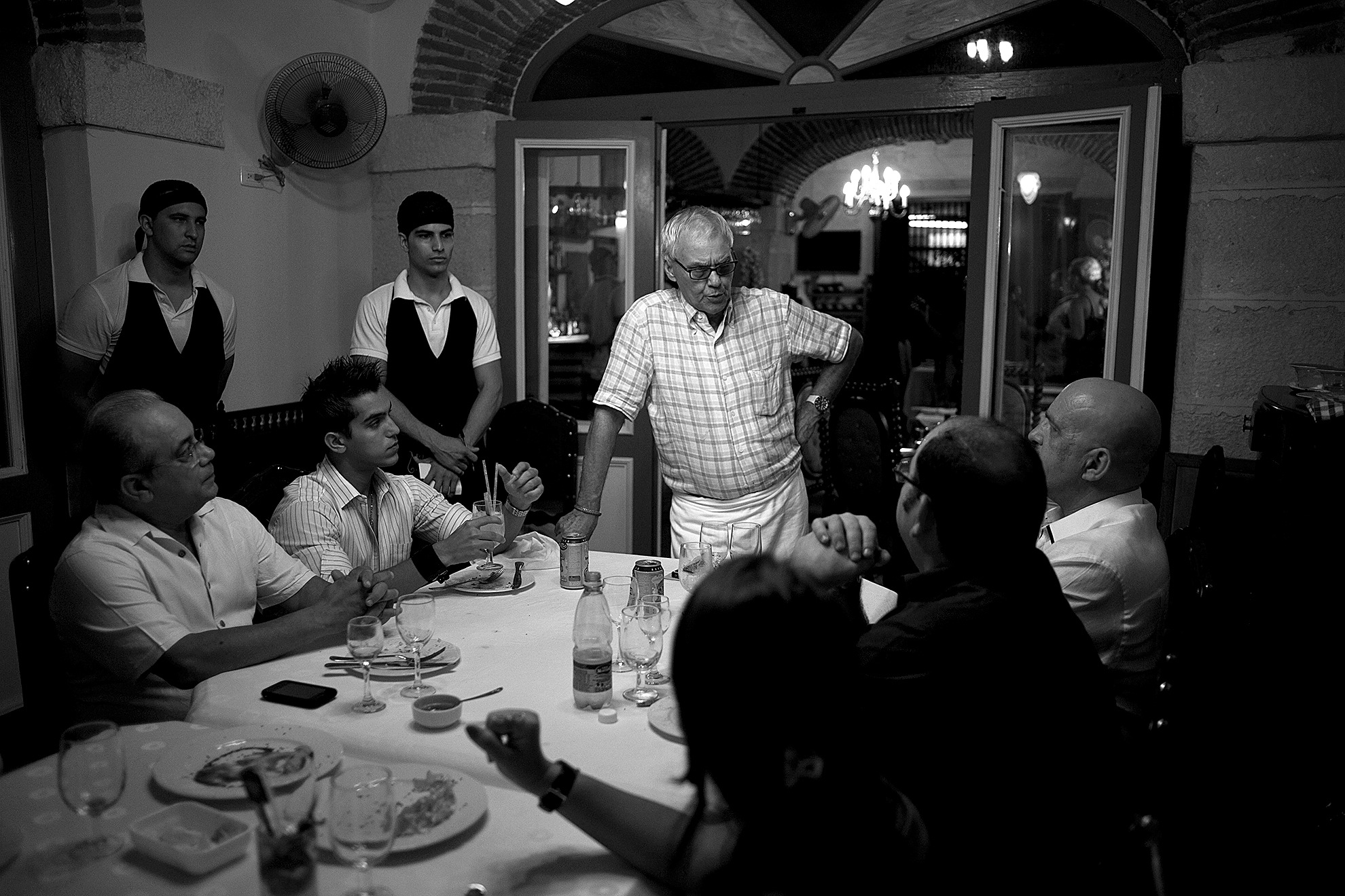 Ramon Espinosa / Associated Press                                Tomas Erasmo Hernandez (center), owner of the private restaurant Mama Ines, chats with customers in Old Havana, Cuba, in 2012.