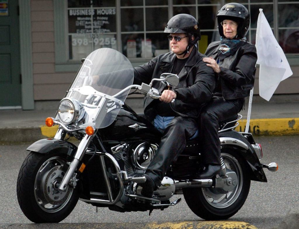 Sister Georgette Bayless, 82, rides on the back of the Kawaski Vulcan Classic motorcycle driven by Dean Felthous of Snohomish before leaving Mill Creek for her first motorcycle ride Saturday for the second annual Angel Ride for Hospice. The event is a fund-raiser for Providence Hospice and Home Care of Snohomish County which Bayless founded 26 years ago. (Justin Best/The Herald)
