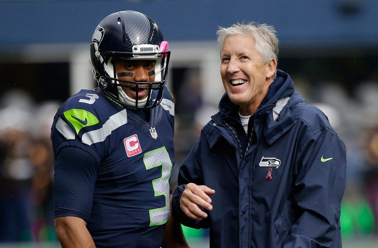 Seahawks quarterback Russell Wilson (left) talks with head coach Pete Carroll before a game against the Falcons on Oct. 16 in Seattle. (AP Photo/Elaine Thompson)