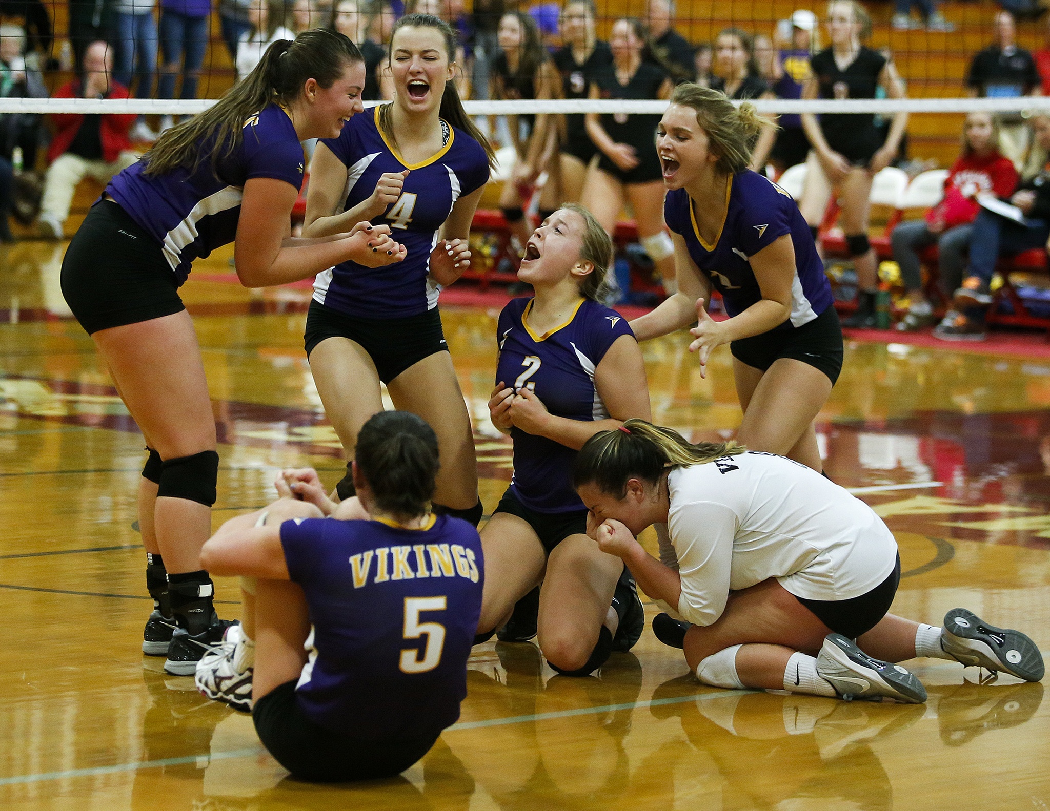 Lake Stevens players (from left) Hannah Aaenson, Gabby Gunterman (5), Grace Schroedl, Lilly Eason, Emily Lubick and Melissa Stevens celebrate together after scoring the final point to defeat Monroe for the 4A District 1 championship Thursday at Marysville Pilchuck High School. (Ian Terry / The Herald)