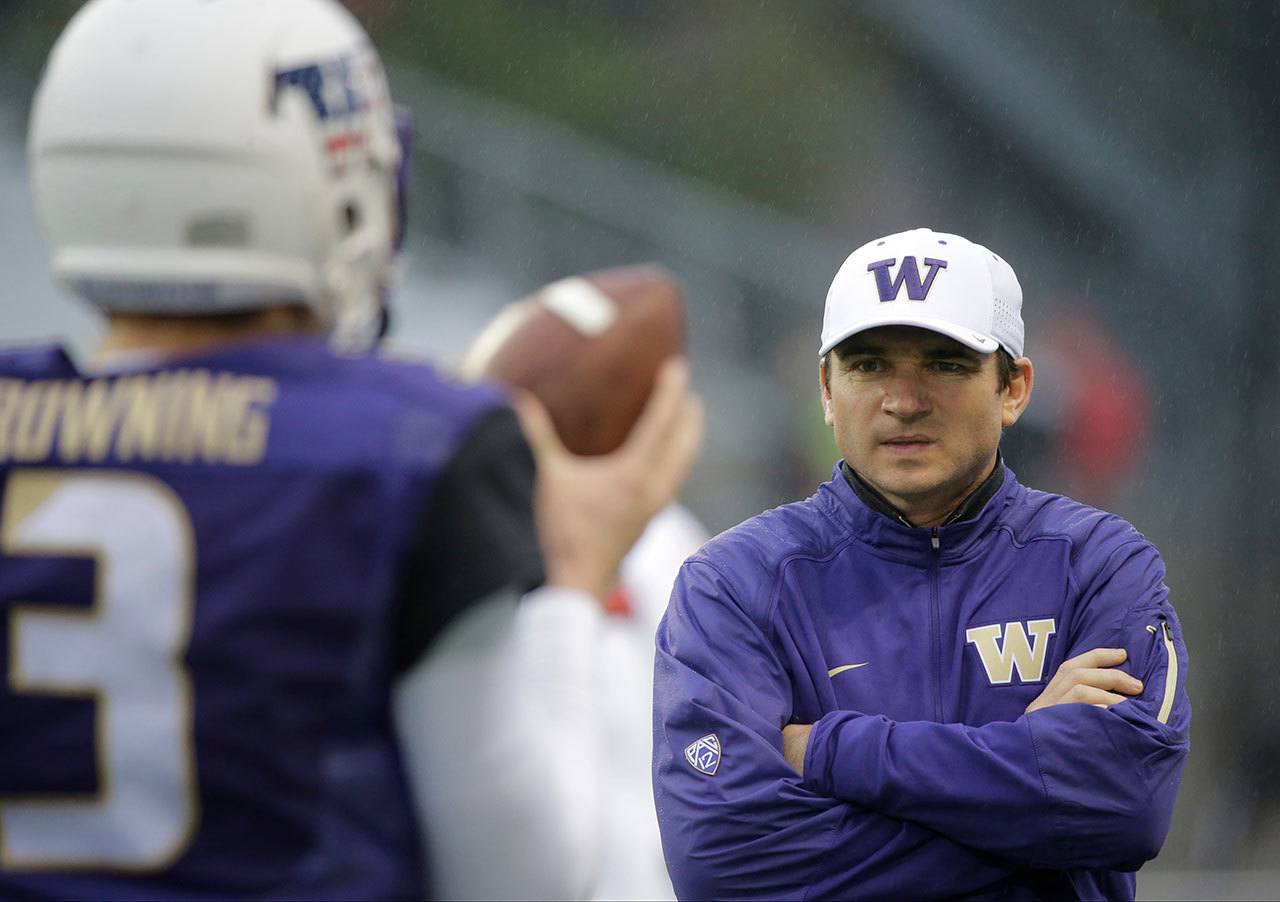 Washington offensive coordinator Jonathan Smith (right) looks on as quarterback Jake Browning goes through warm-ups before a game against Utah last season in Seattle. The oft-criticized Smith has the Huskies’ offense firing on all cylinders so far this season. (AP Photo/Ted S. Warren)
