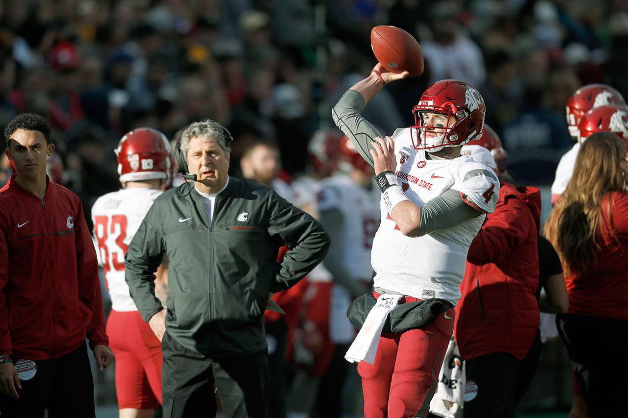 Washington State’s Luke Falk (right) warms up as coach Mike Leach looks on in the first half of the Cougars’ game against Colorado last Saturday in Boulder, Colo. Falk leads the Cougars against Washington in the Apple Cup on Friday. (AP Photo/David Zalubowski)
