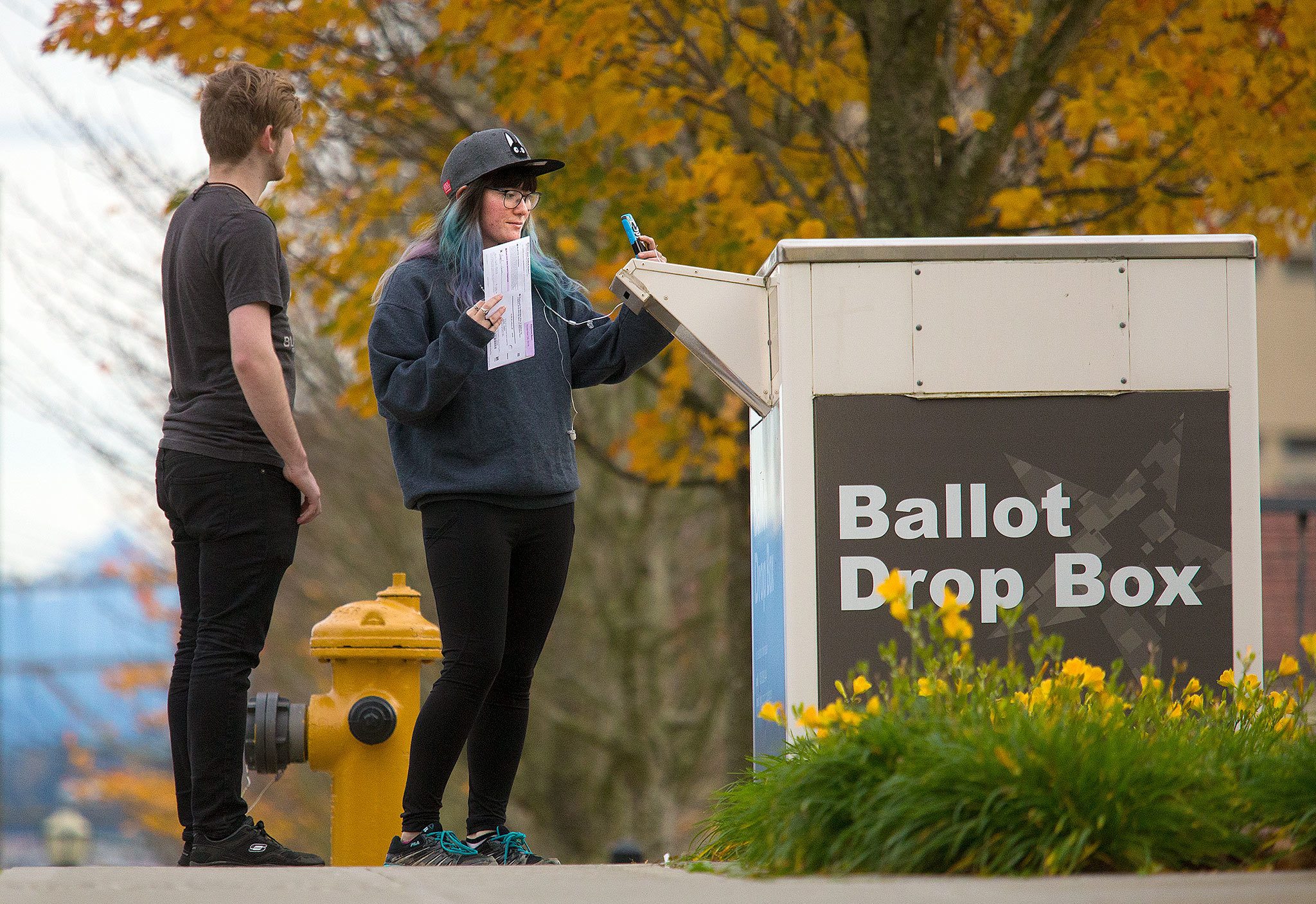 Maximillian Roberts, 21, watches as Angel Green, 20, takes a selfie before dropping off her ballot after voting her first presidential race on Monday, Nov. 7, 2016 in Everett, Wa. “It’s been an interesting race,” says Green. (Andy Bronson / The Herald)