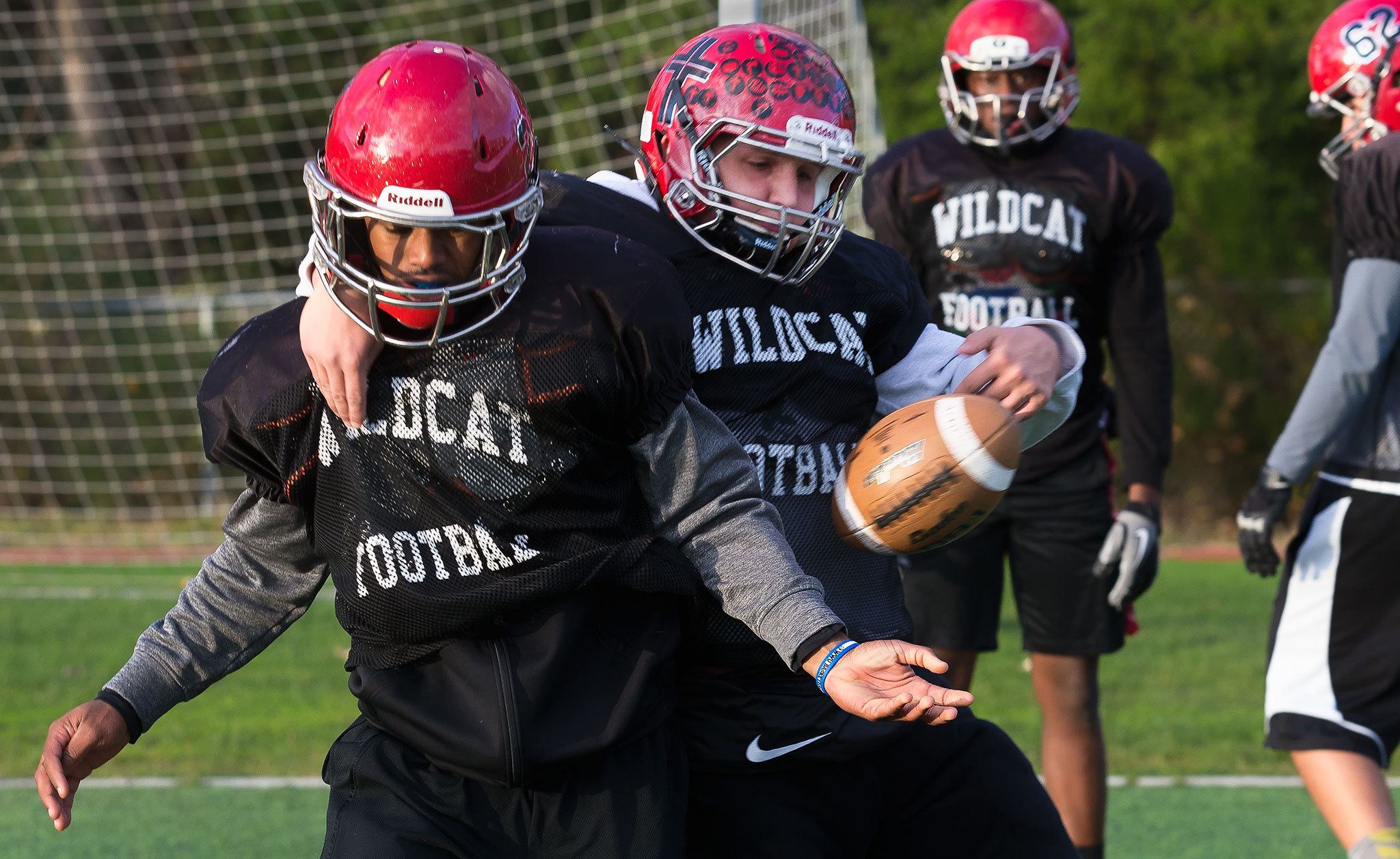 Junior linebacker Ben Hines (middle) strips the ball from teammate Fredrico Girault as Archbishop Murphy football players go through defensive drills on Thursday in Everett. (Andy Bronson / The Herald)
