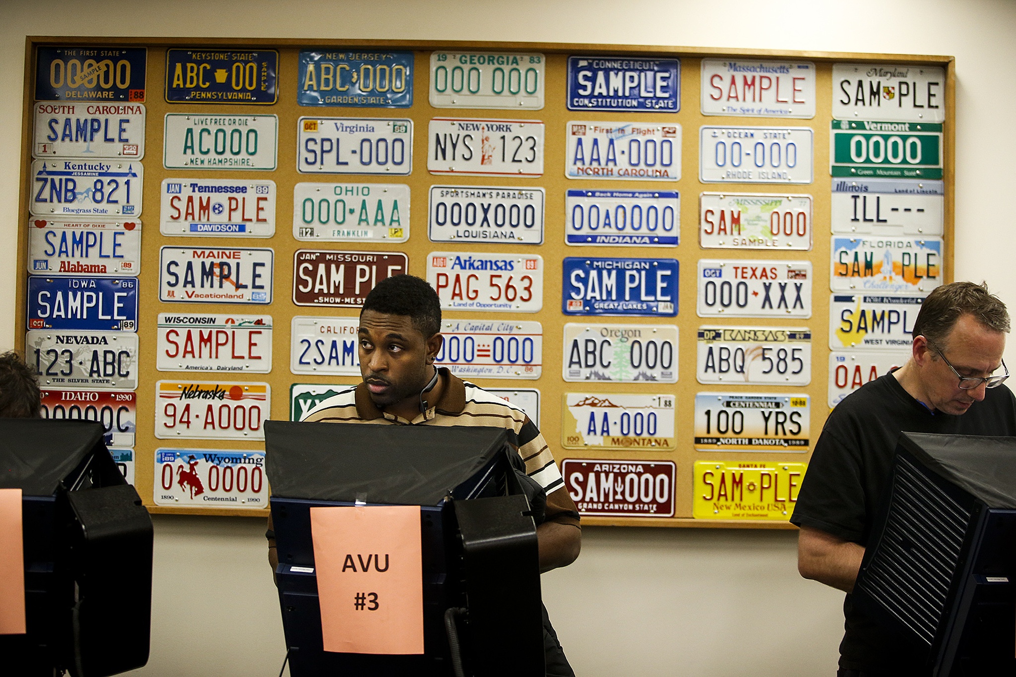 Delvin Ebbesen (left), of Everett, uses an accessible voting unit to cast his ballot at the Snohomish County campus building in Everett on Tuesday. (Ian Terry / The Herald)