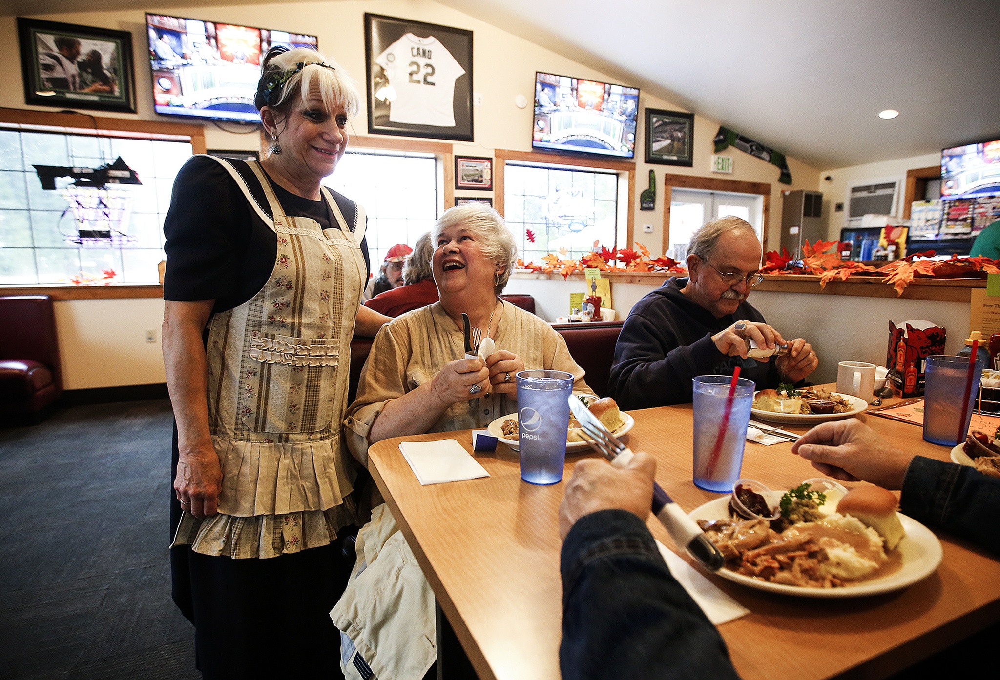 Cheri Fenstermaker (left) chats with Joan (center) and Marvin Kastning after serving them their Thanksgiving meals at The Hawks Nest restaurant in Darrington on Thursday, Nov. 24. The Hawks Nest opened their doors and served the usual Thanksgiving fanfare in a gesture to give back to the community that has welcomed them since first opening in April. (Ian Terry / The Herald)
