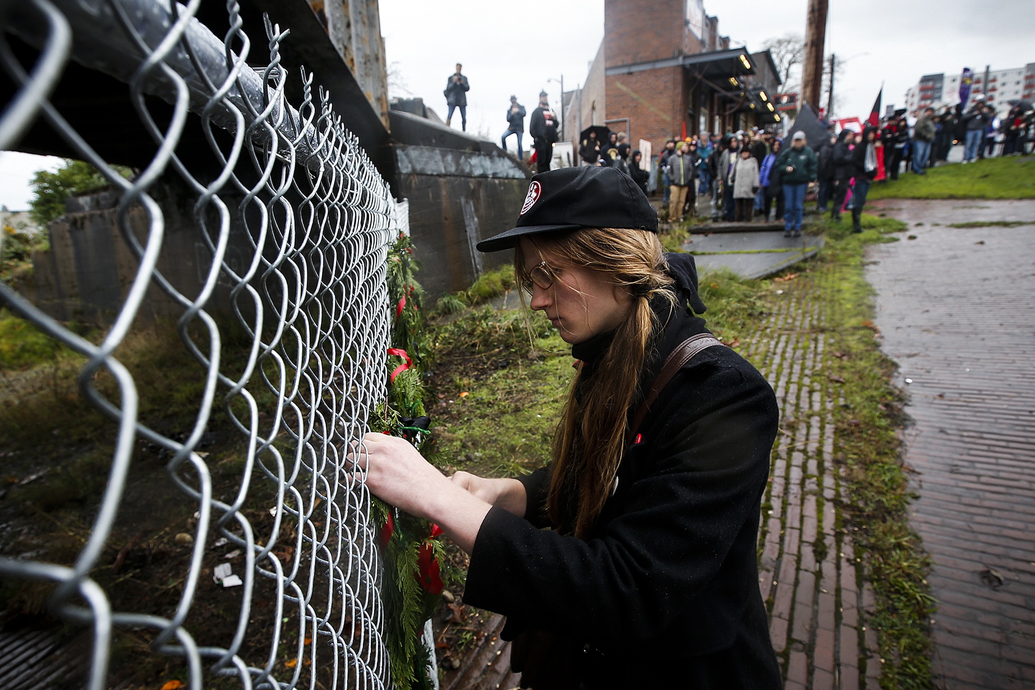 Miriam Ball, of Olympia, hangs a wreath to honor a victim of the Everett Massacre on Saturday, marking 100 years since the event in which Industrial Workers of the World members were gunned down as they attempted to come ashore near downtown Everett’s waterfront. (Ian Terry / The Herald)
