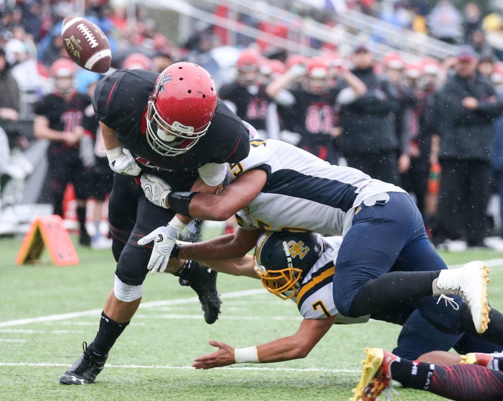 Archbishop Murphy’s Collin Montez fumbles the ball out of bound forced by Burlington-Edison’s Terrel Cameron, top, and Brett Rawlins Saturday afternoon at Terry Ennis Stadium on November 5, 2016. (Kevin Clark / The Herald)