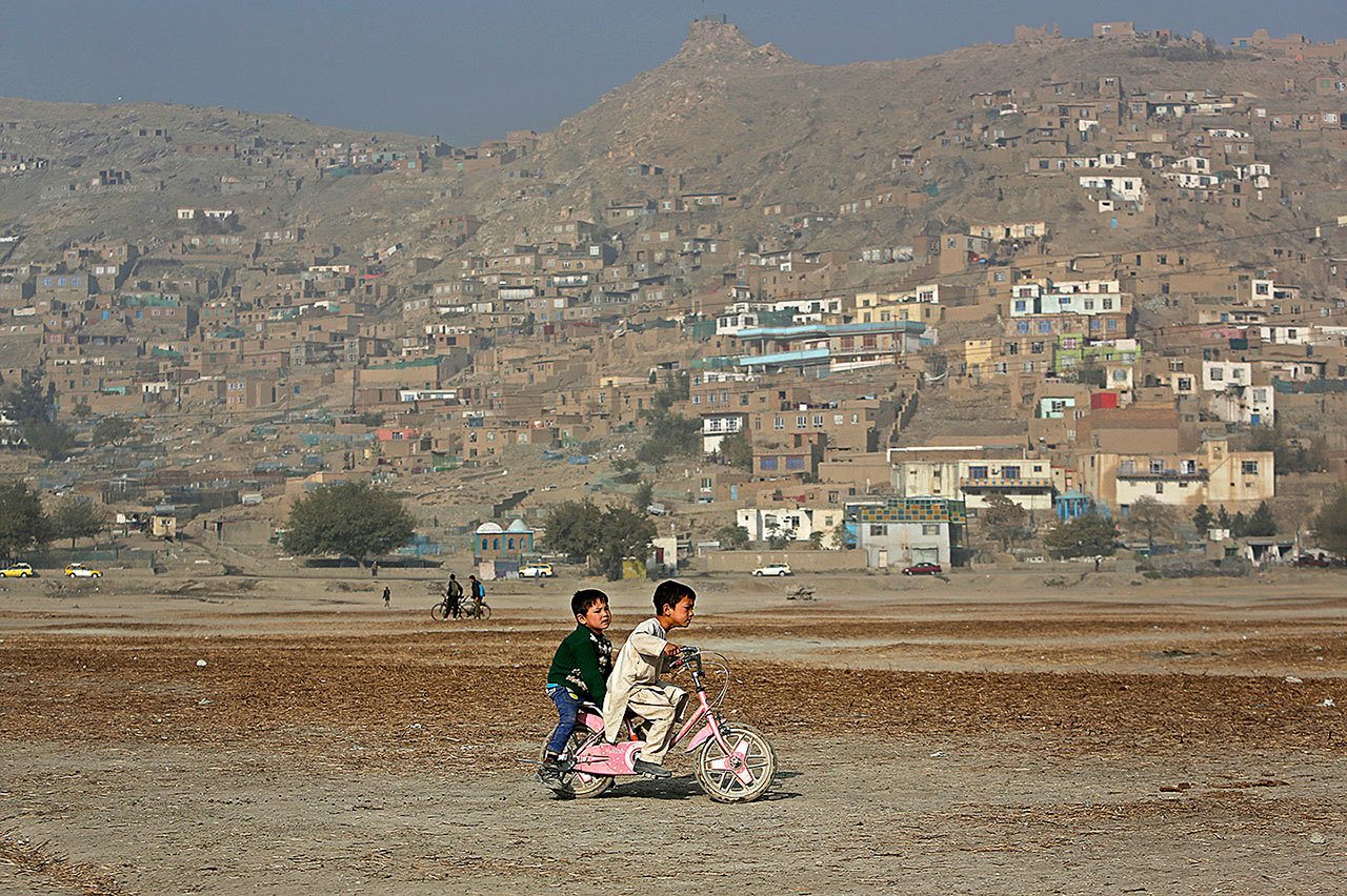 Haseebullah 7, rides his bicycle with a friend on the outskirts of Kabul, Afghanistan, on Thursday, Nov. 3. (AP Photo/Rahmat Gul)