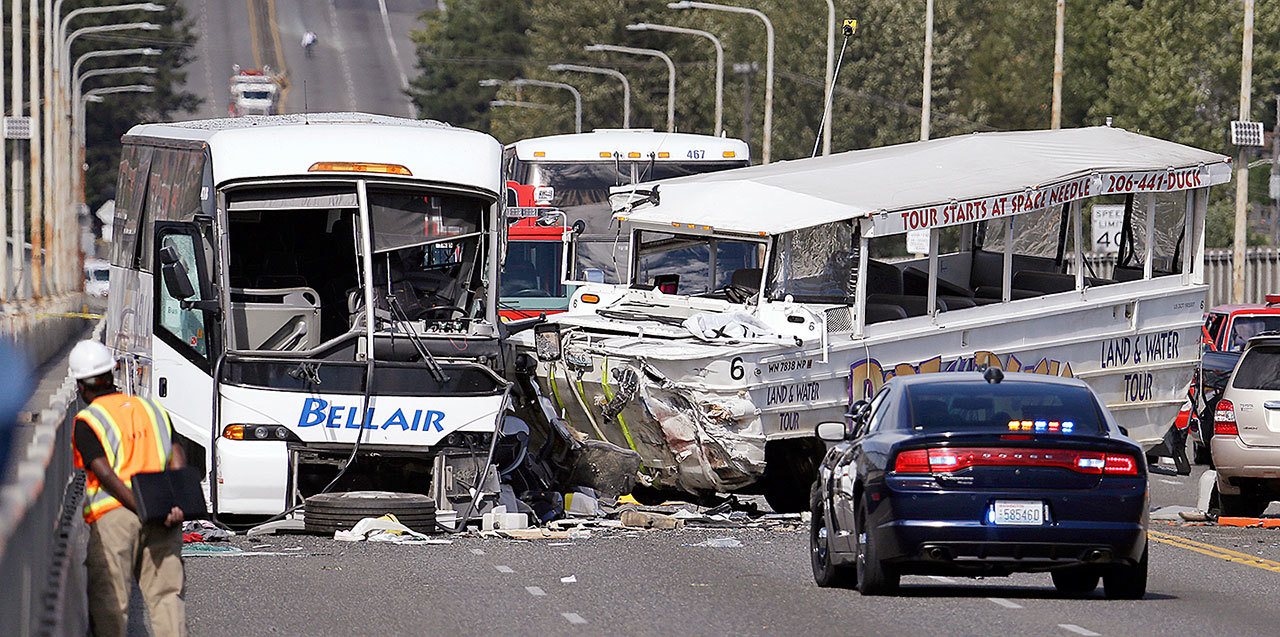 This Sept. 24, 2015, photo shows a “Ride the Ducks” amphibious tour bus (right) and a charter bus at the scene of a fatal collision on the Aurora Bridge in Seattle. The National Transportation Safety Board meets Tuesday, Nov. 15, to determine the probable cause of the crash of the Ride the Ducks vehicle after it crossed the center line into oncoming traffic while driving over the bridge. (AP Photo/Elaine Thompson, File)