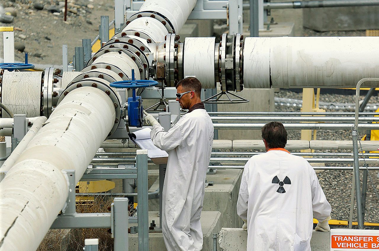 In this 2014, photo, workers wearing protective clothing and footwear inspect a valve at the “C” tank farm on the Hanford Nuclear Reservation near Richland, Washington. A report released Wednesday found that seven of 52 workers interviewed were worried about fear of retaliation related to raising concerns about exposure to chemical vapors escaping from nuclear waste storage tanks. (AP Photo/Ted S. Warren, File)