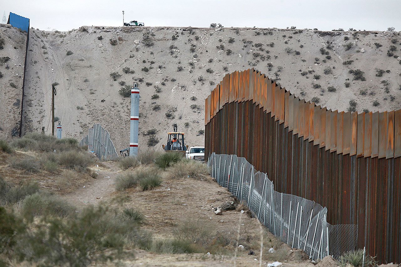 Workers continue work raising a taller fence in the Mexico-U.S. border area separating the towns of Anapra, Mexico, and Sunland Park, New Mexico, on Thursday, Nov. 10. An Arizona Native American tribe has said it will not support the building of a wall on their land. (AP Photo/Christian Torres)
