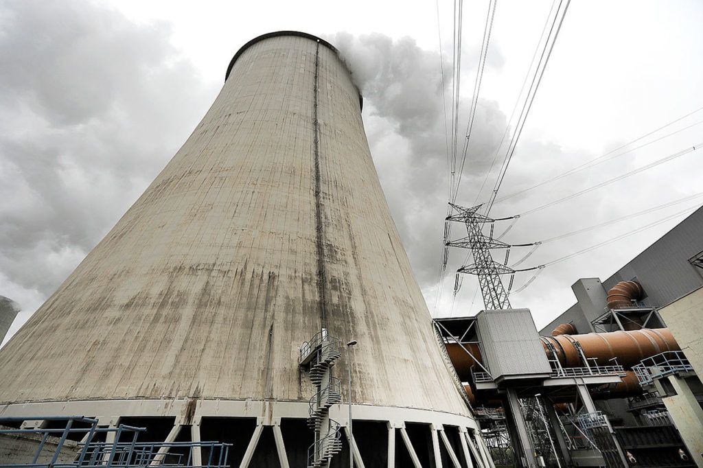 In this Oct. 28 photo, an electricity pylon stands next to a cooling tower at the LEAG (Lusatian Energy Stock Company) lignite power plant in Jaenschwalde, eastern Germany. Scientists studying lifetime emissions of the world’s current energy infrastructure say coal plants alone would blow the budget for 1.5 degrees C of warming, the lower threshold in the Paris climate agreement. (AP Photo/Michael Sohn)
