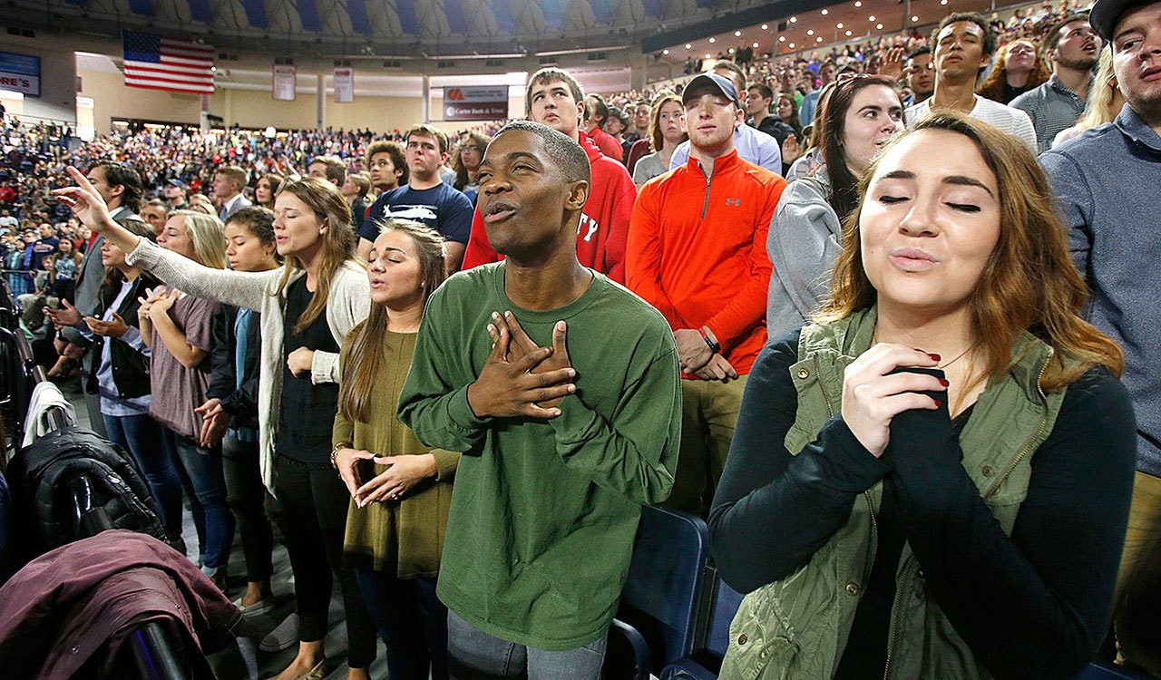 In this Oct. 12 photo, Liberty University students sing and pray prior to a speech by Republican vice presidential candidate, Indiana Gov. Mike Pence, at Liberty University in Lynchburg, Virgina. Evangelicals, deeply divided over Republican presidential candidate Donald Trump, are wrestling with what the tumultuous 2016 election will mean for their future. (AP Photo/Steve Helber)