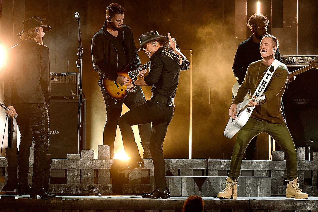 Tim McGraw, center, Brian Kelley, left, and Tyler Hubbard, right, of Florida Georgia Line, perform at the 50th annual CMA Awards at the Bridgestone Arena on Nov. 2 in Nashville, Tenn. (Photo by Charles Sykes/Invision/AP)