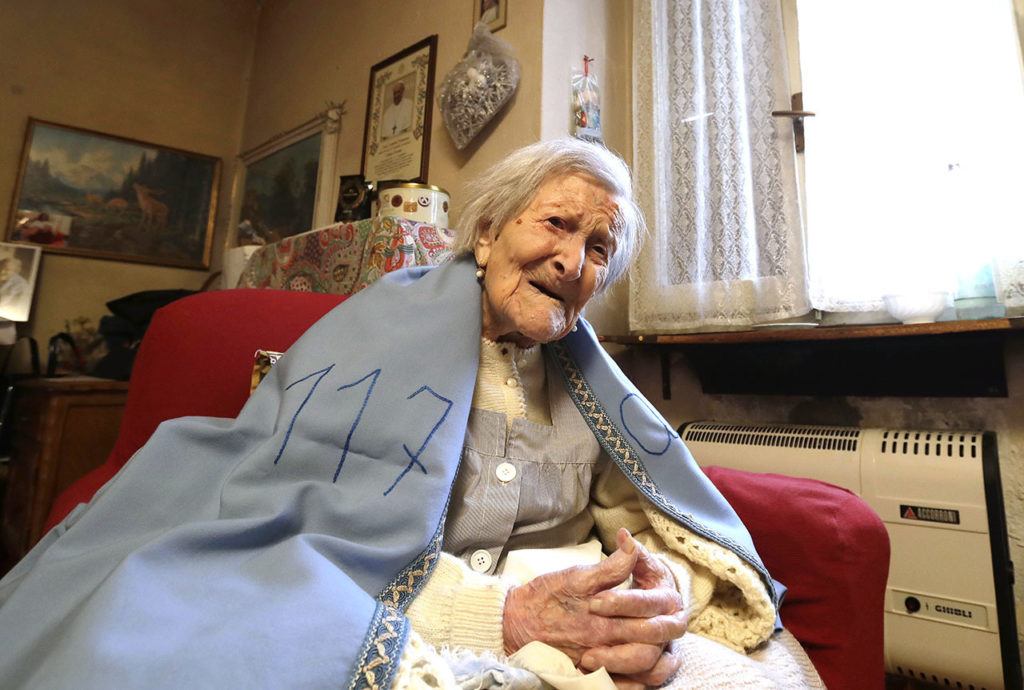 Emma Morano wears a sheet reading “117” on her 117th birthday at her home in Verbania, Italy, on Tuesday, Nov. 29. (AP Photo/Antonio Calanni)

