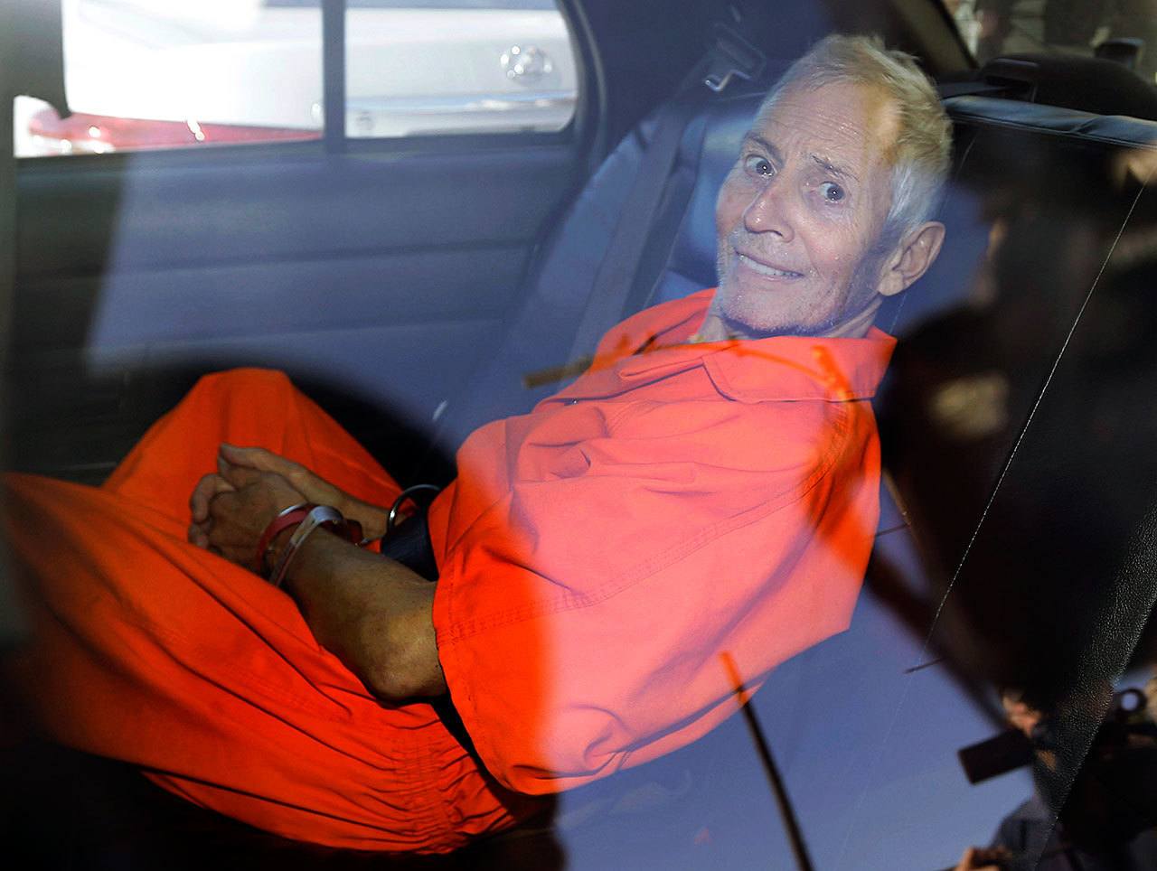 In March 17, 2015, photo, New York real estate heir Robert Durst smiles as he is transported from Orleans Parish Criminal District Court to the Orleans Parish Prison after his arraignment on murder charges in New Orleans. (AP Photo/Gerald Herbert, File)