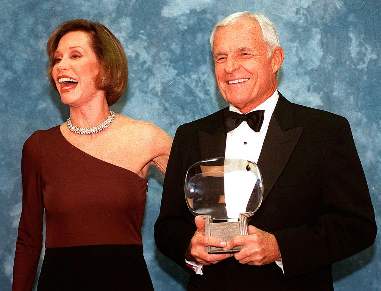 In this 1997 photo, Television executive Grant Tinker holds up his Hall of Fame award alongside his ex-wife, Mary Tyler Moore, at the Academy of Television Arts & Sciences’ 13th Annual Hall of Fame induction ceremonies in the North Hollywood section of Los Angeles. Tinker, who brought “The Mary Tyler Moore Show” and other hits to the screen as a producer and a network boss, died Monday, Nov. 28, at his home in Los Angeles, according to his son, Mark Tinker. (AP Photo/Chris Pizzello, File)