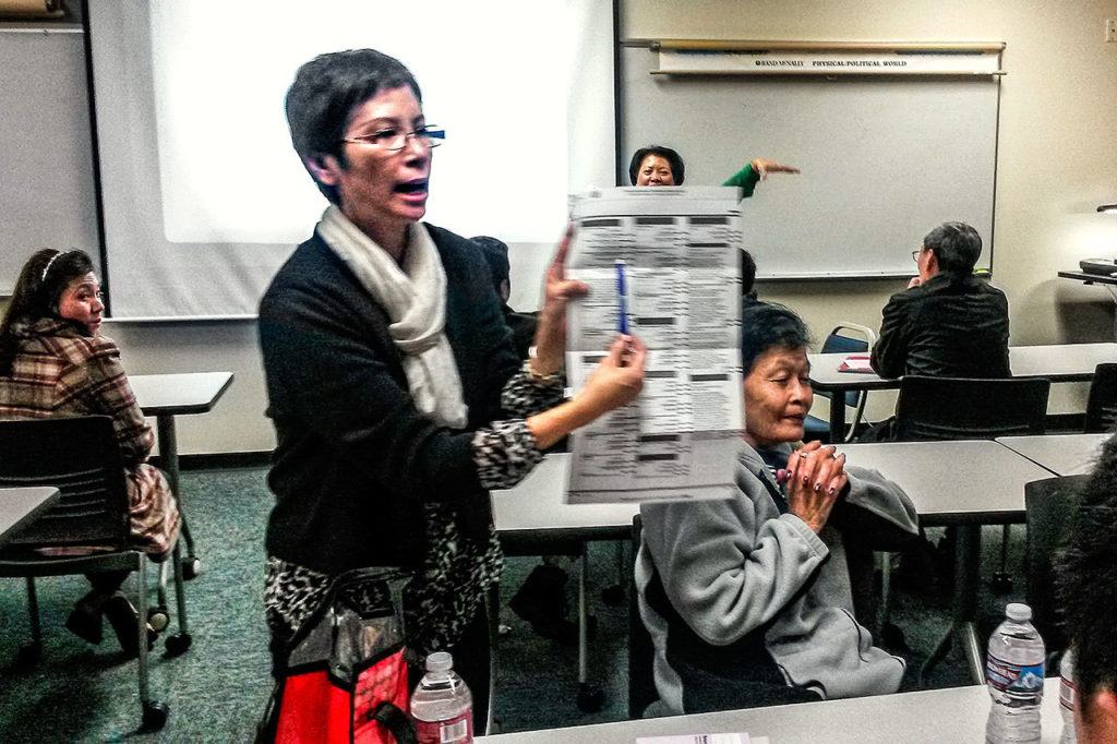 Nia Bell, who speaks Vietnamese, explains and answers questions about the ballot during the event. (Julie Muhlstein / The Herald)
