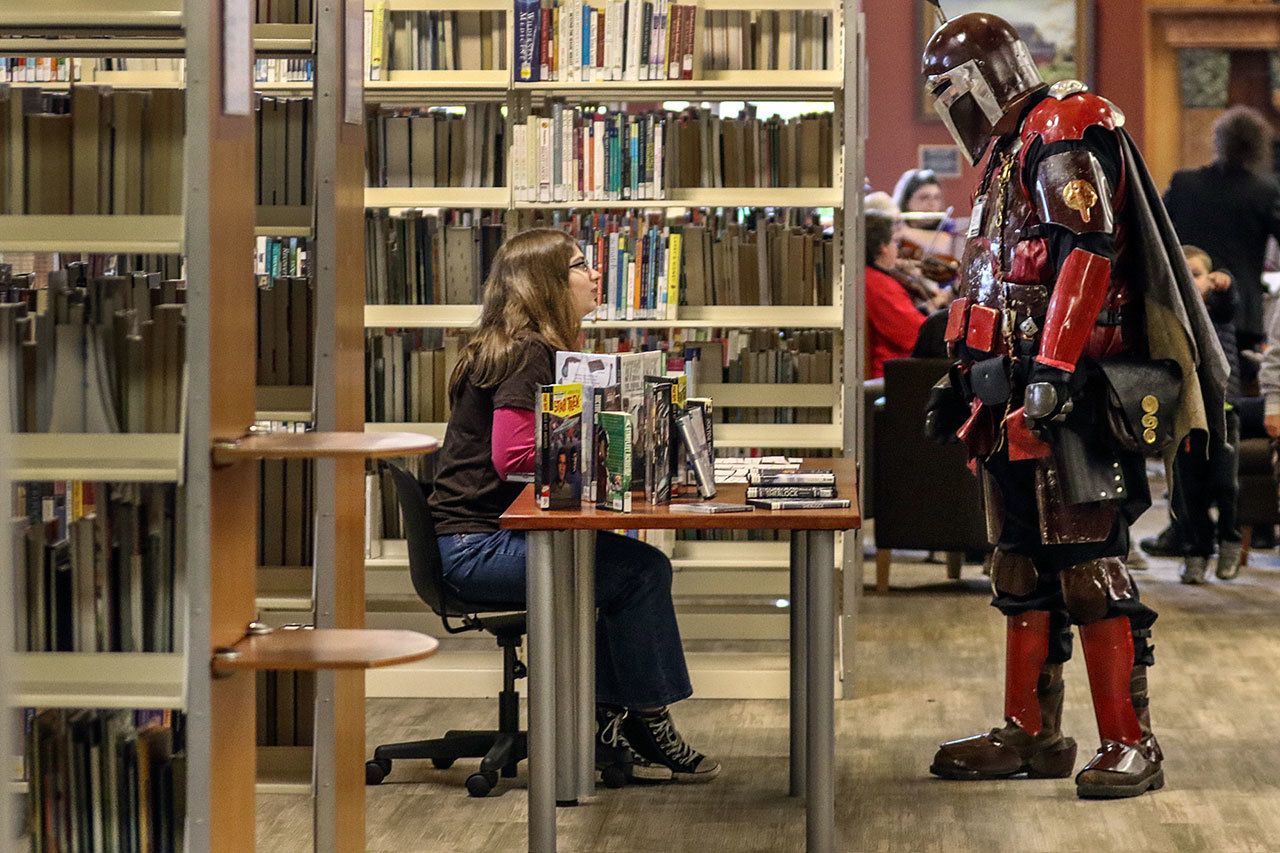 Chloe Taton, left, talks with Shane Harris during the Sno-Isle ComicCon on Sunday morning at the Snohomish Library. (Kevin Clark / The Herald)