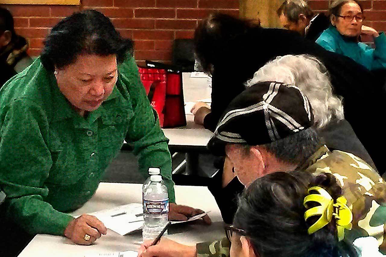 Van Dinh-Kuno (left), executive director of Refugee and Immigrant Services Northwest, answers questions about the general election ballot at an event sponsored by the Asian Pacific Islander Coalition on Friday at Everett Community College. Participants were U.S. citizens needing help from interpreters before casting their votes. (Julie Muhlstein / The Herald)