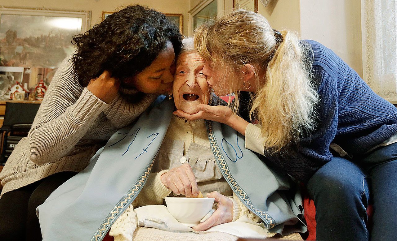 Emma Morano, 117 years hold, is kissed by her caretakers Malgorzat Ceglinska (right) and Yamilec Vergara on her birthday in Verbania, Italy, Tuesday, Nov. 29. Emma is now the oldest person in the world and is believed to be the last surviving person in the world who was born in the 1800s, coming into the world on Nov. 29, 1899. (AP Photo/Antonio Calanni)