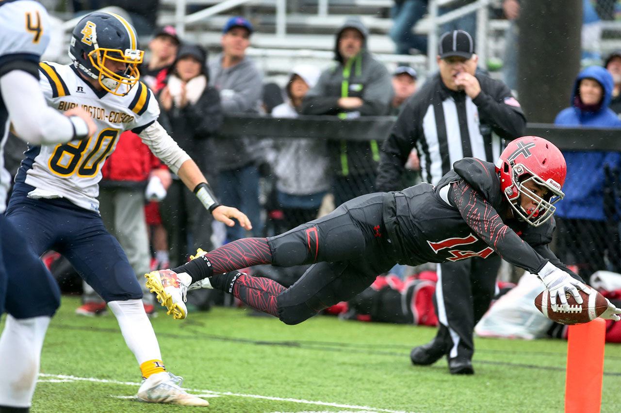 Archbishop Murphy’s Anfernee Gurley dives for the pylong with Burlington-Edison’s Mitchell Wesen trailing during the Wildcats’ 55-6 victory over the Tigers in a 2A bi-district playoff game on Saturday in Everett. (Kevin Clark / The Herald)
