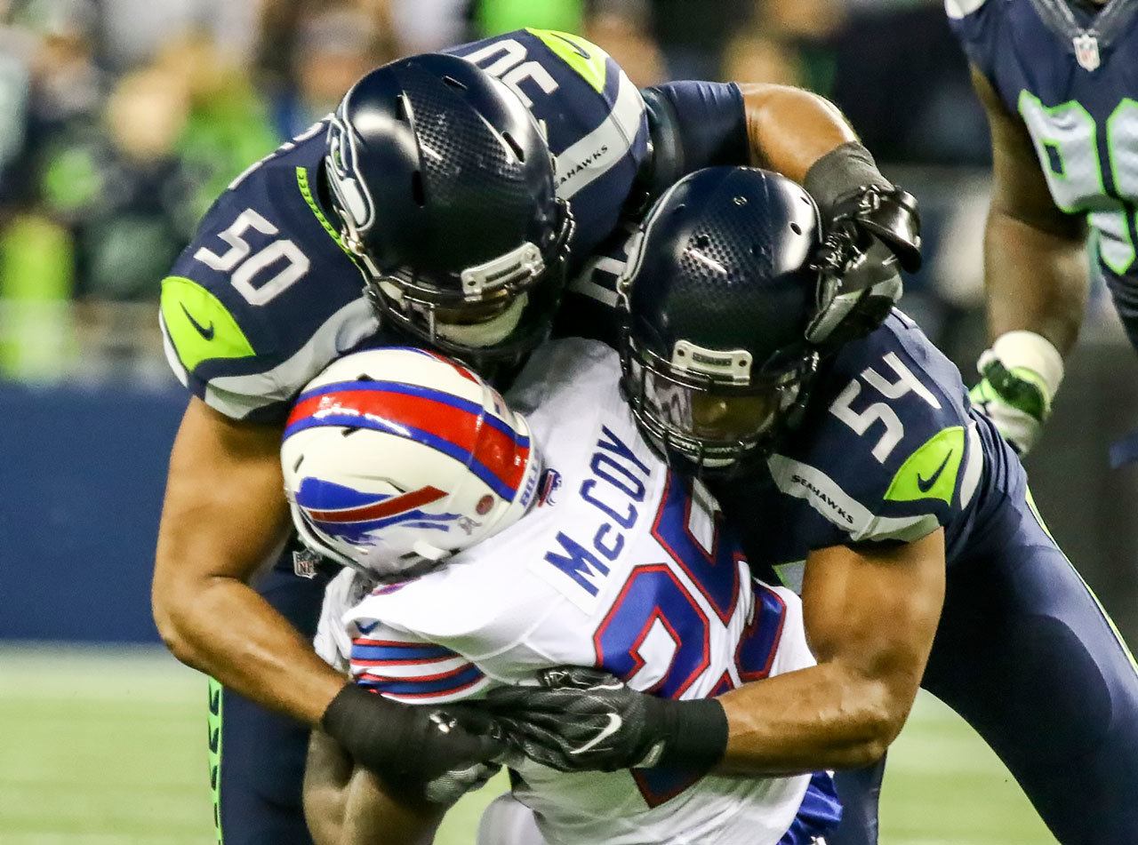 Seahawks linebackers K.J. Wright (50) and Bobby Wagner (54) tackle Bills running back LeSean McCoy during Monday night’s game at CenturyLink Field in Seattle. (Kevin Clark / The Herald)