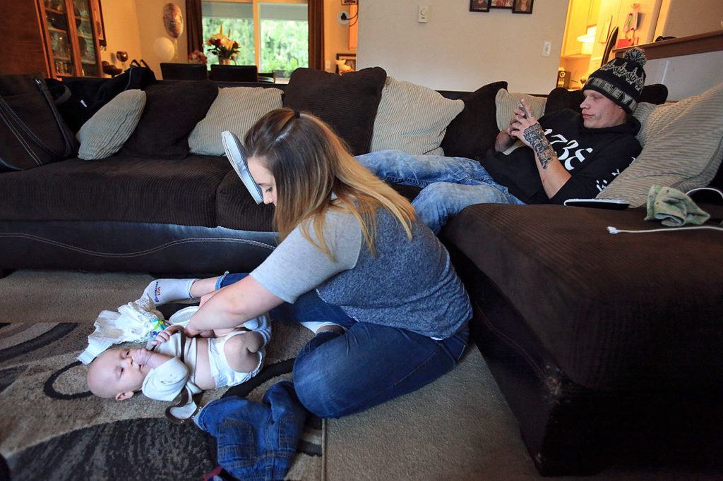 Brayden Varnes gets his diaper changed by his mom, Jessiana King, with Jacob Varnes at her home in Granite Falls. (Kevin Clark / The Herald)
