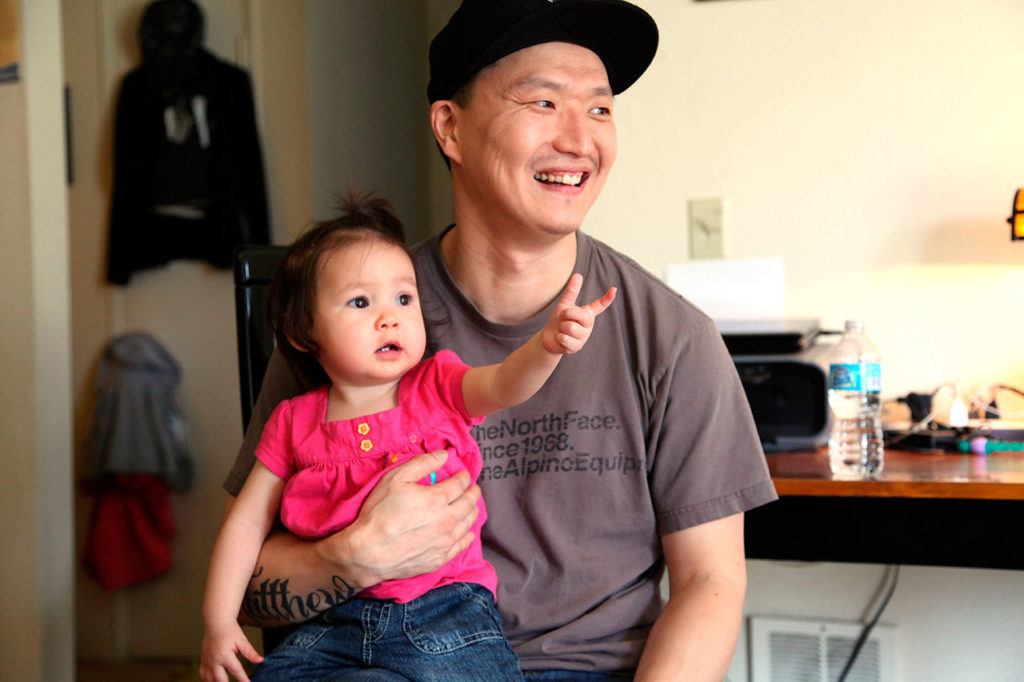 Korean adoptee Adam Crapser poses with daughter, Christal, 1, in the family’s living room in Vancouver, Washington. (AP Photo/Gosia Wozniacka, file)
