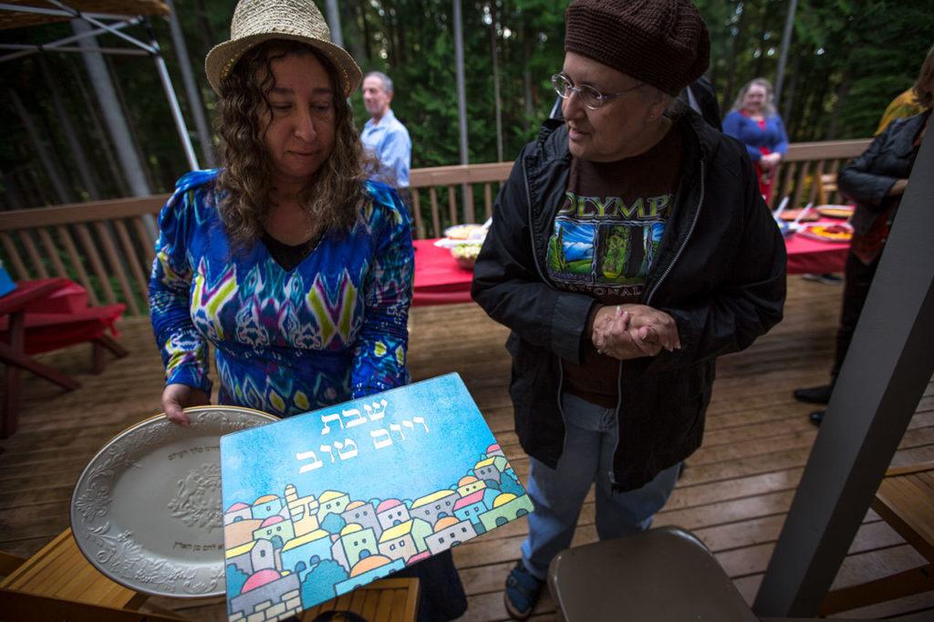 Iris Shamas shows a couple of her challah dishes to Helen Grossman. (Daniella Beccaria / For The Herald)
