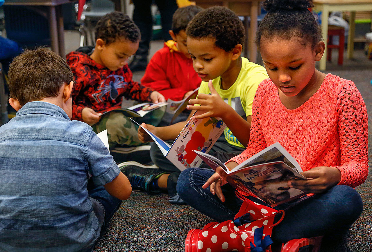 Kindergarteners (from left) Asher Wheatley, Quentin Cook, Iokua Baker, Elijah Stewart and Cai Williams-Smith dive right into the new books. The books are part of a $35,000 gift of supplies from Inspirus Credit Union to the Edmonds School District. (Dan Bates / The Herald)
