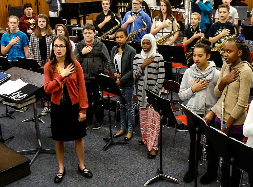 North Middle School band and choir director, Emily Cheever leads her class saluting the flag at the start of the day, June 15. (Dan Bates / The Herald)
