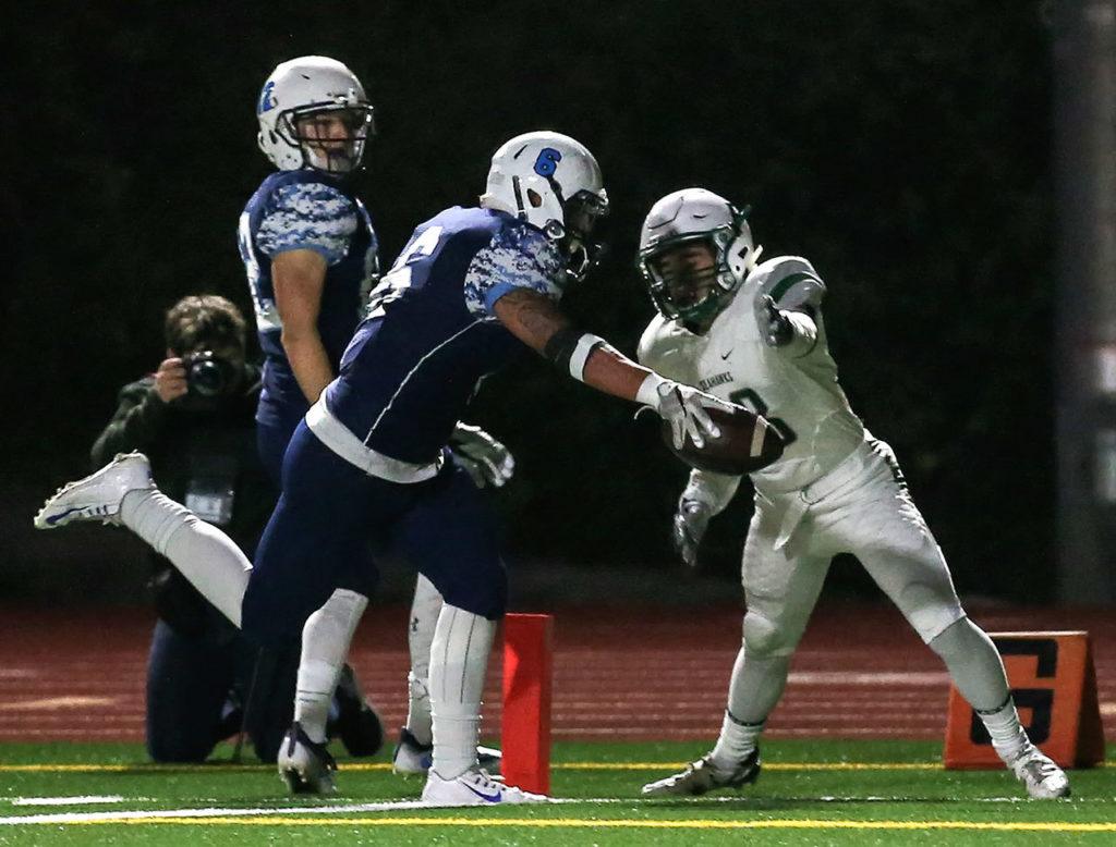 Meadowdale’s Kela Marshall crosses the goal line with teammate Drew Harvey looking on and Peninsula’s Ozzy Marten defending during a 3A state quarterfinal game Friday at Edmonds Stadium. (Kevin Clark / The Herald)
