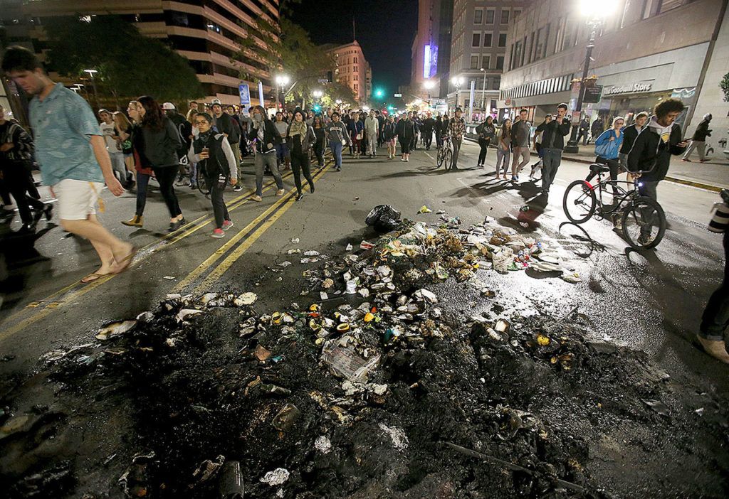 Protesters march past burned garbage in downtown Oakland, California, on Wednesday, Nov. 9. President-elect Donald Trump’s victory set off multiple protests. (Jane Tyska/Bay Area News Group via AP)
