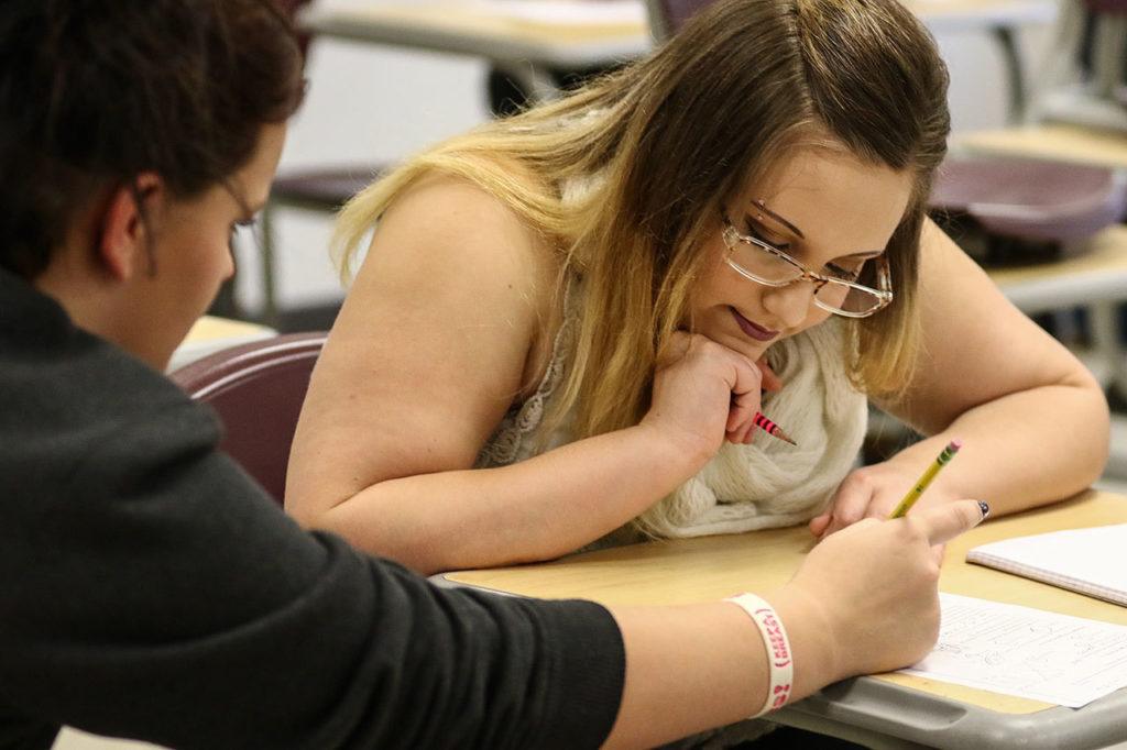 Rhianna Conrad (left) helps Jessiana King with her math during class at Crossroads Higs School in Granite Falls. King is taking part in the GRADS program for teen parents as a full-time student. (Kevin Clark / The Herald)
