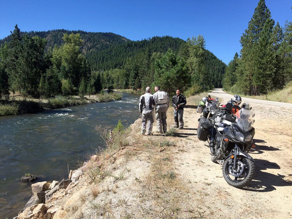 John VanHersett (from left), Reg Rumwell and Justin Ladd pause by the Bitterroot River just south of Darby, Montana, on their way to the Magruder Corridor. (Photo by Jon Stanley)
