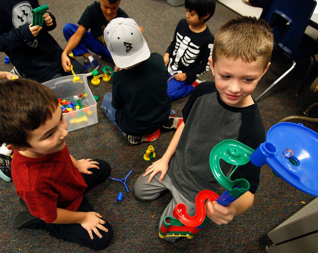 Third-graders Legacy Marshall (left) and Peyton Whitaker in Wynne Webster’s class at Beverly Elementary School in Lynnwood test an educational marble tower they constructed while other students get started on similar tasks. (Dan Bates / The Herald)
