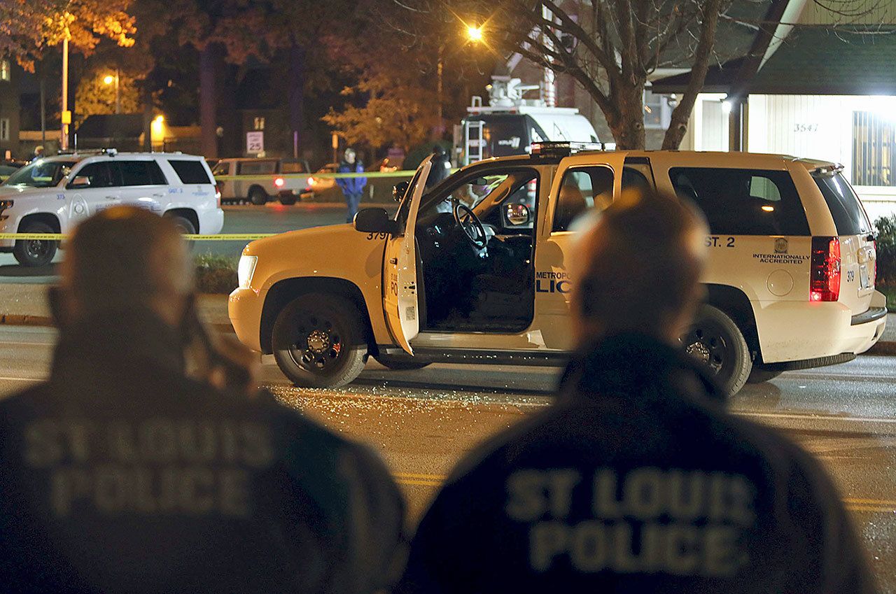 Police investigate a scene after a St. Louis police officer was shot in what the police chief called an “ambush” on Sunday, Nov. 20, in St. Louis. Police Chief Sam Dotson said the 46-year-old officer was shot in the face. The suspect got away and a massive search was underway. (David Carson/St. Louis Post-Dispatch via AP)