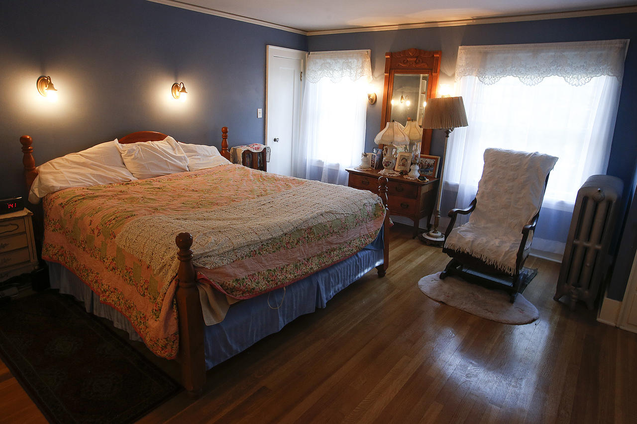 The master bedroom has an open wood floor and antique light fixtures. (Ian Terry / The Herald)
