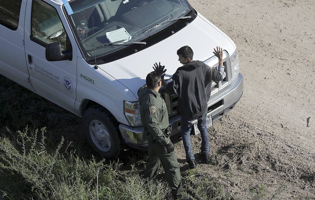 In this Nov. 16, photo, a U.S. Customs and Border Patrol agent works with a suspected immigrant entering the country illegally along the Rio Grande in Hidalgo, Texas. (AP Photo/Eric Gay)
