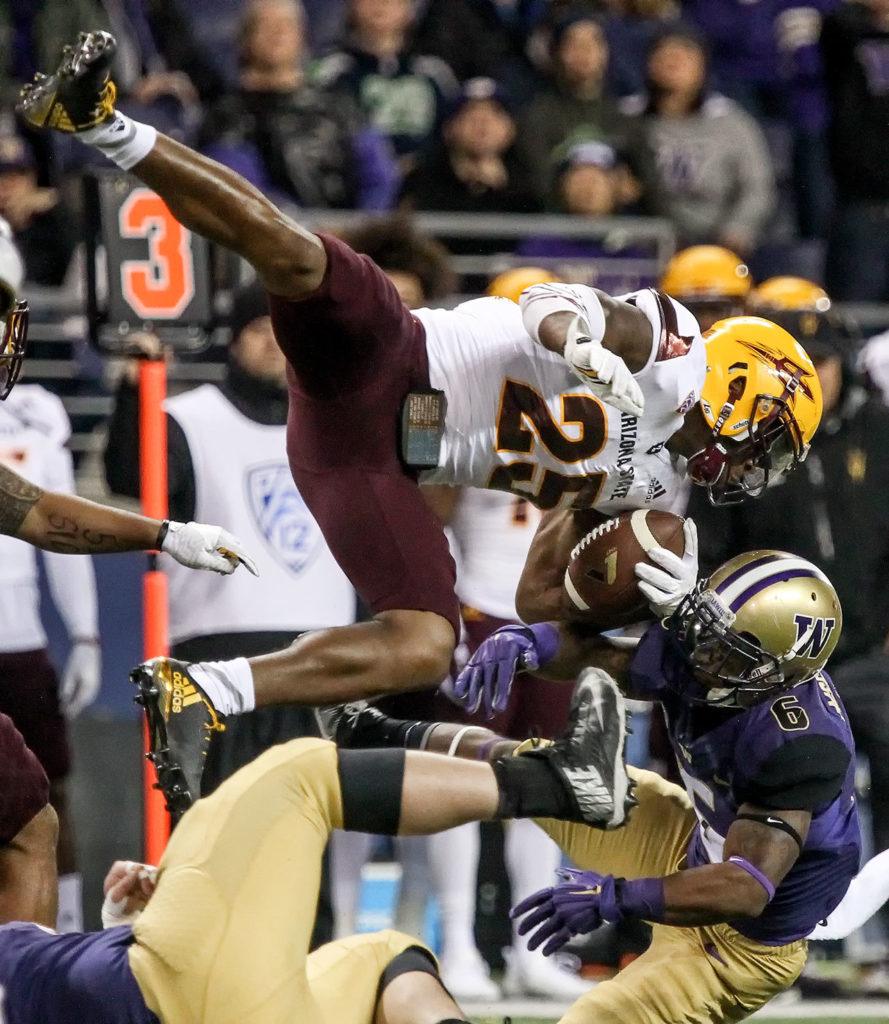 Arizona State’s Kareem Orr is upended after an interception by Washington offensive lineman Coleman Shelton (bottom left) and Washington wide receiver Chico McClatcher on Saturday at Husky Stadium in Seattle. (Kevin Clark / The Herald)

