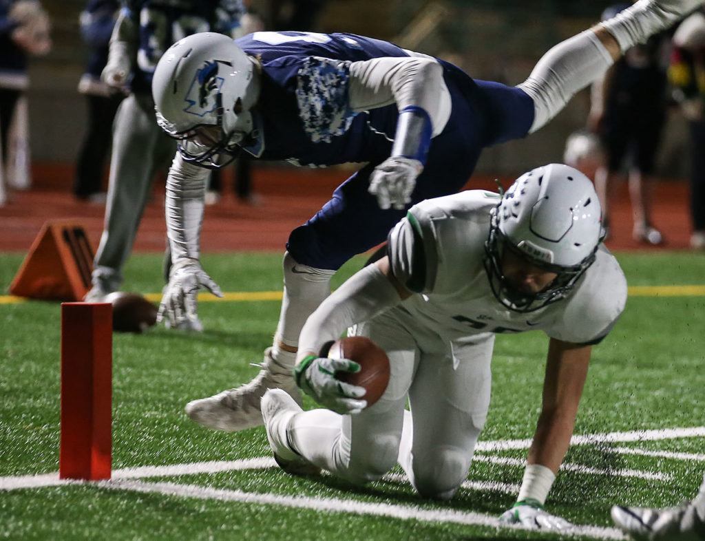 Peninsula’s Kenny Easton reaches across the goal line for a touchdown with Meadowdale’s Jackson Foltz attempting a stop during a 3A state quarterfinal game Friday at Edmonds Stadium. (Kevin Clark / The Herald)

