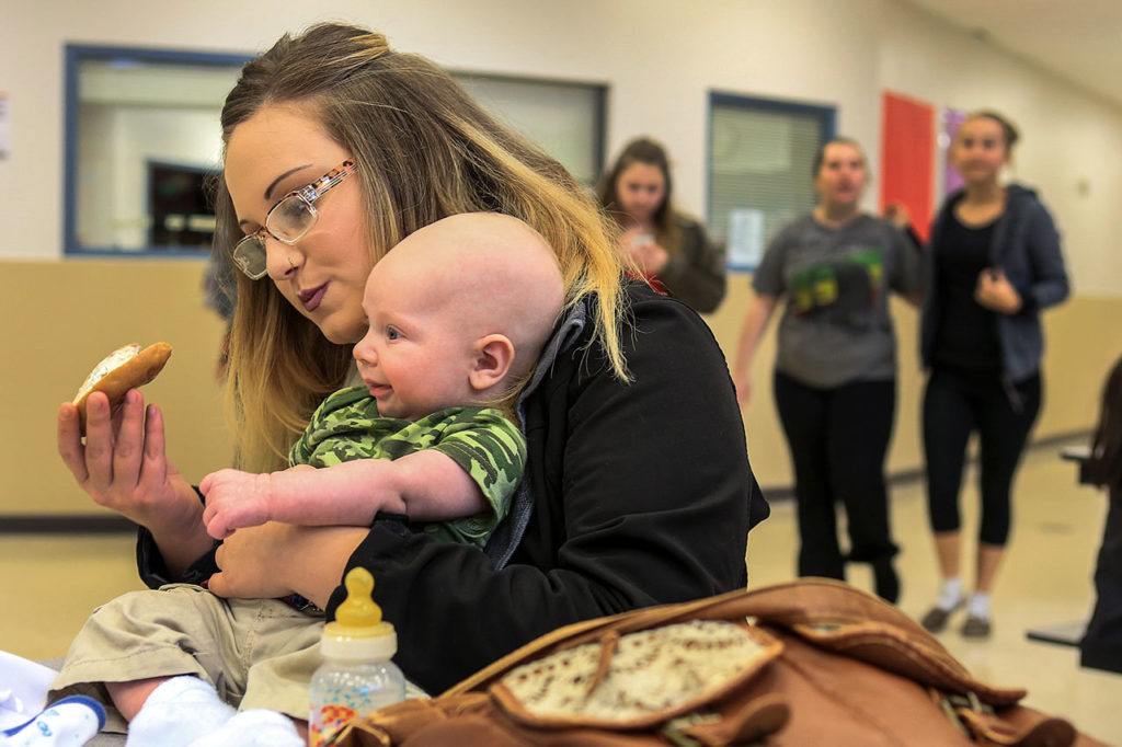 Jessiana King holds her son, Brayden Varnes, during a lunch period at Crossroads High School in Granite Falls. Crossroads offers childcare and King spends every lunch with Brayden and friends. (Kevin Clark / The Herald)
