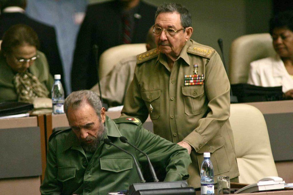 Dec. 23, 2004: Fidel Castro is helped into his chair by his brother Raul Castro as he arrives to the National Assembly in Havana, Cuba. (AP Photo/Dario Lopez-Mills, File)
