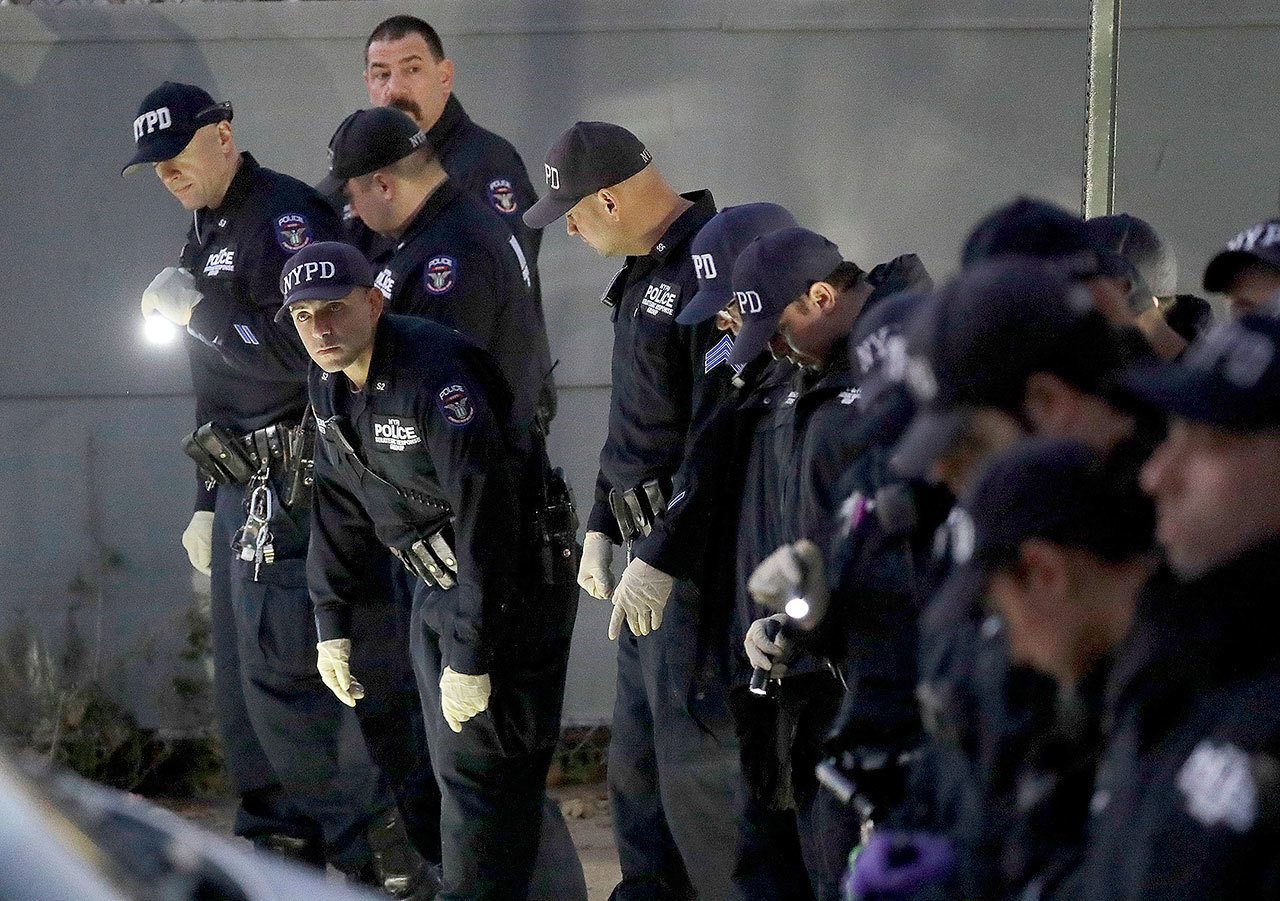 New York City Police officers search for clues on a street where a shooting took place in the Bronx borough of New York on Friday. (AP Photo / Julio Cortez)