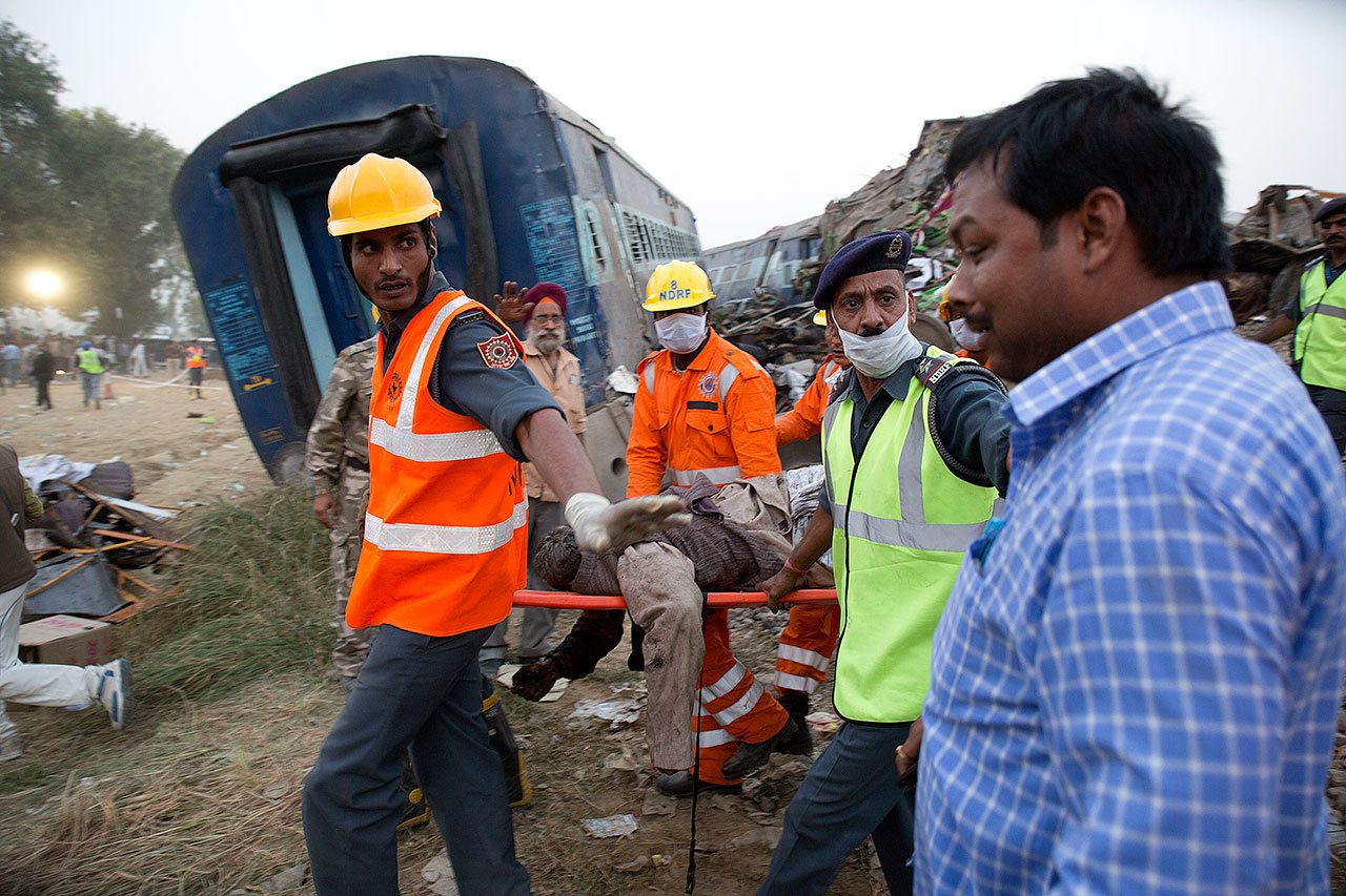 A relative (right) breaks down as rescuers carry the body of a victim after 14 coaches of an overnight passenger train rolled off the track near Pukhrayan village, India, on Sunday, Nov. 20, 2016. (AP Photo/Rajesh Kumar Singh)