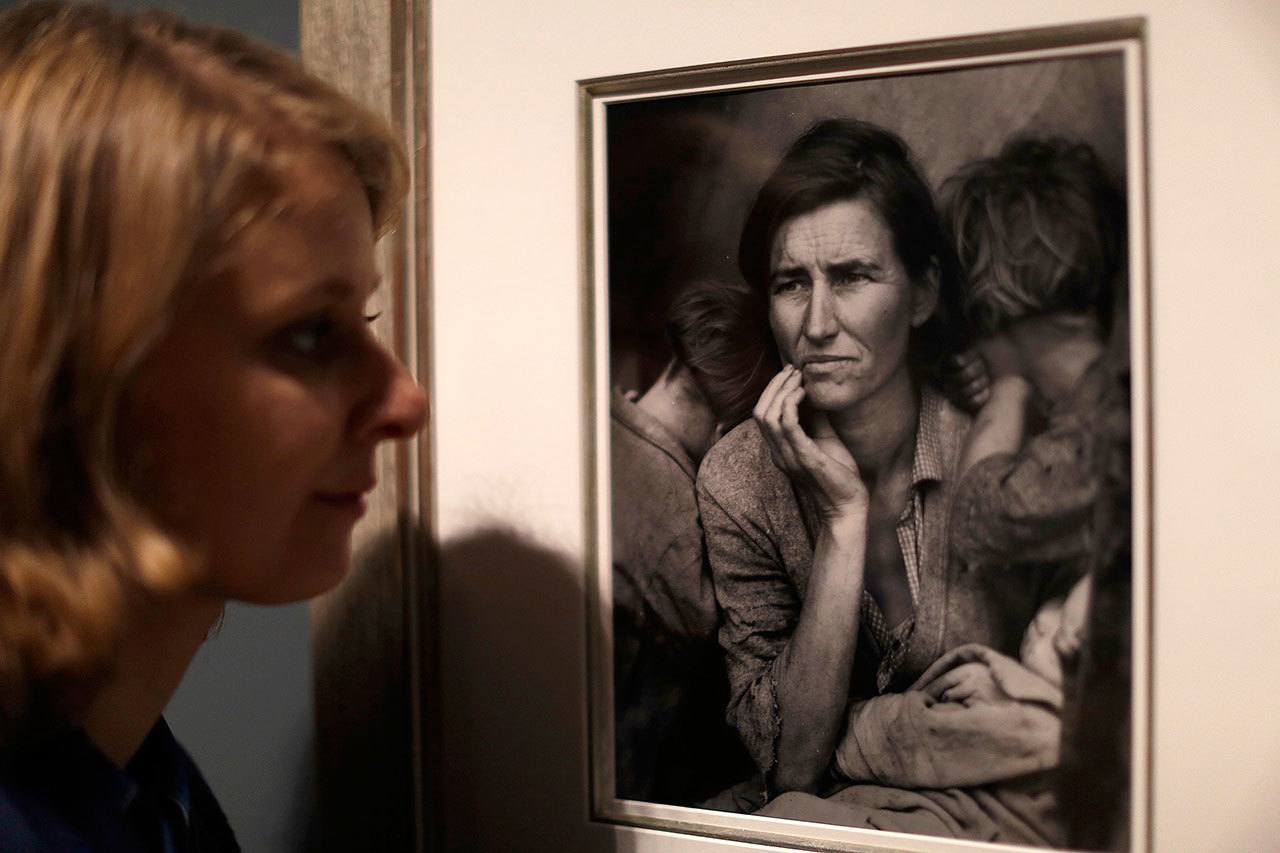 A Tate member of staff poses next to American photographer Dorothea Lange’s “Migrant Mother,” from 1936, at the press view of “The Radical Eye: Modernist Photography from the Sir Elton John Collection” exhibition at the Tate Modern gallery in London on Tuesday. (AP Photo / Matt Dunham)