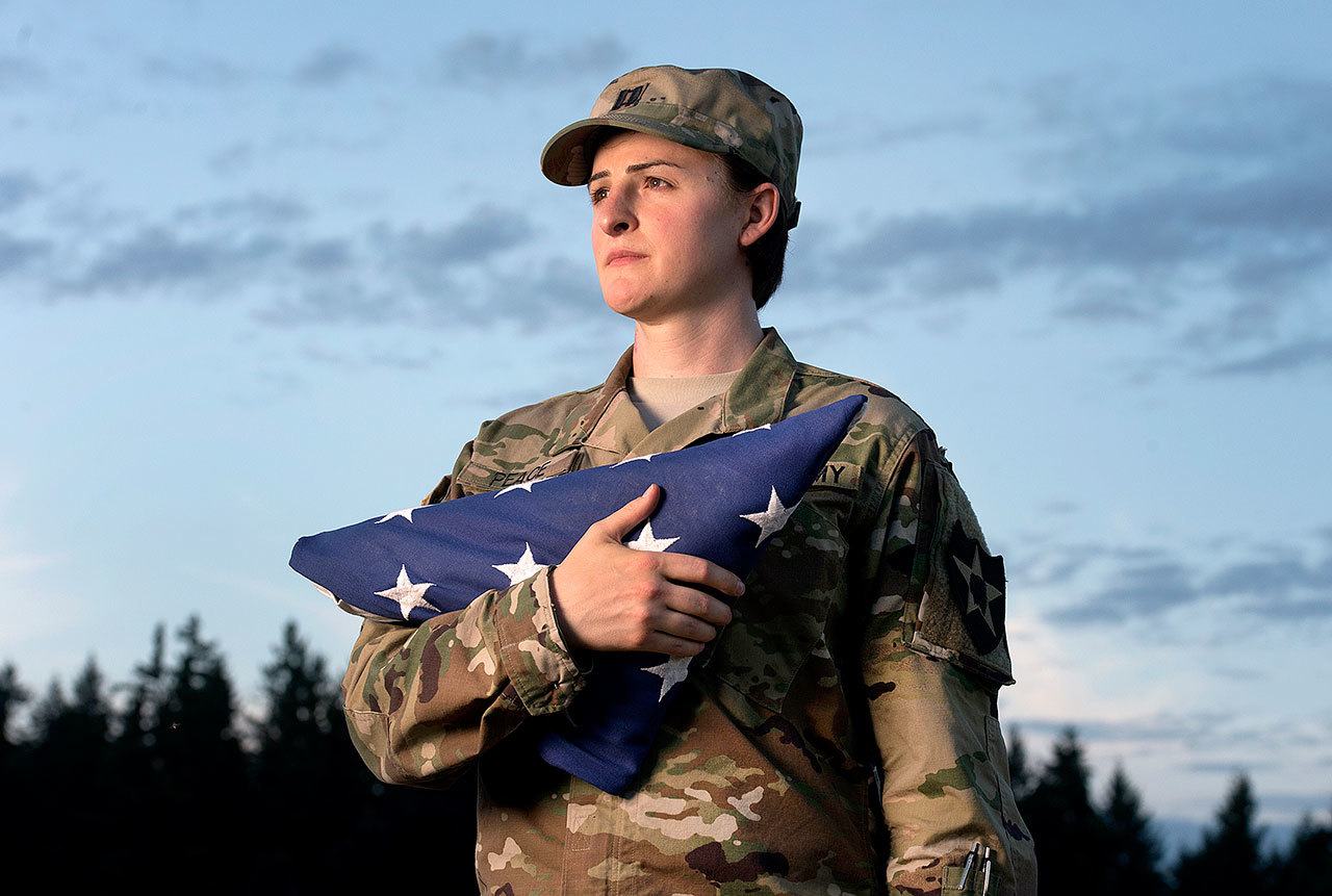 Capt. Jennifer Peace holds a flag as she stands for a photo near her home in Spanaway in 2015 . Peace has been been deployed around the world, including Iraq and Afghanistan. When an officer suggested she leave the military rather than deal with the fallout of being a transgender soldier, Peace was taken aback. “I couldn’t believe he said that. I’ve been in the military for 11 years. It’s everything to me. It’s what I do. It’s as much a part of me as anything else.” (Drew Perine / The News Tribune)
