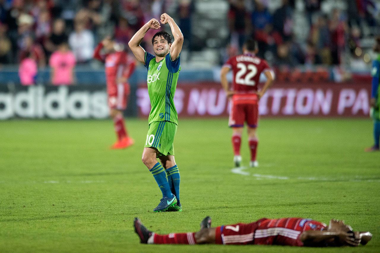 Seattle Sounders midfielder Nicolas Lodeiro (10) celebrates as FC Dallas midfielder Carlos Gruezo lies on the turf at the end of their MLS Western Conference semifinal playoff match Sunday in Frisco, Texas. (AP Photo/Jeffrey McWhorter)